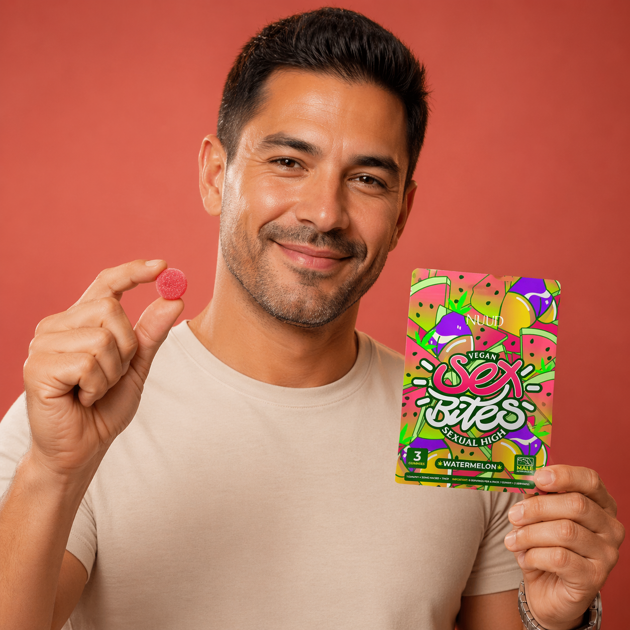 Man holding a pink gummy bear and a colorful package of 'Sex Bites' against a red background